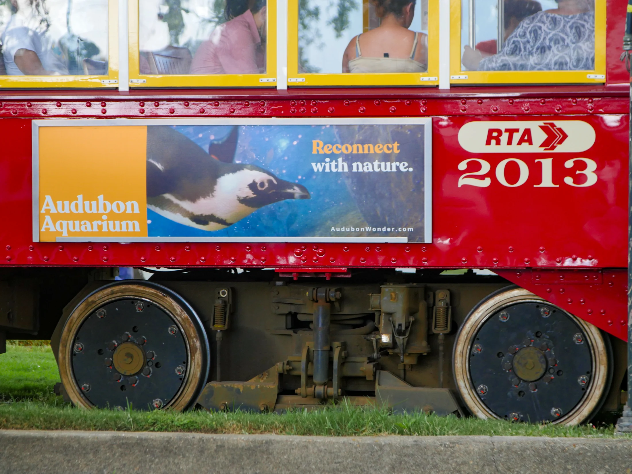 An Audubon Aquarium campaign wraps a red Canal streetcar in New Orleans
