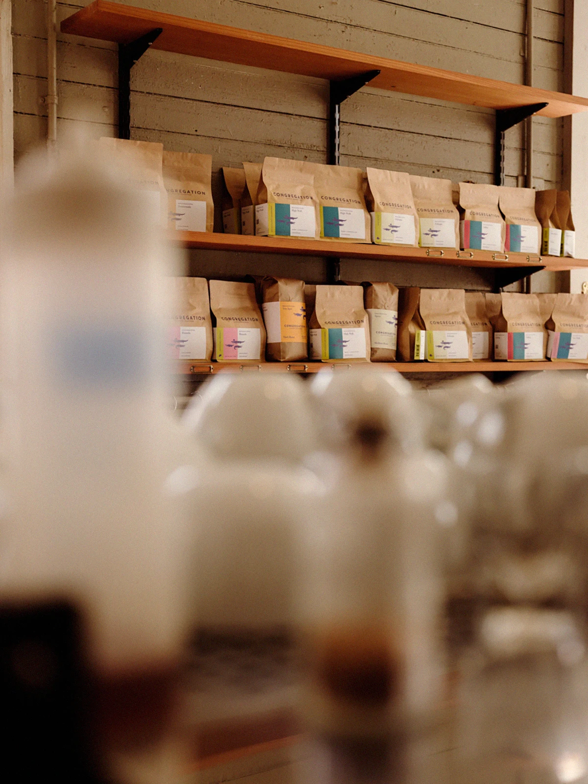 Coffee and merchandise displayed on wooden shelves inside Congregation’s café