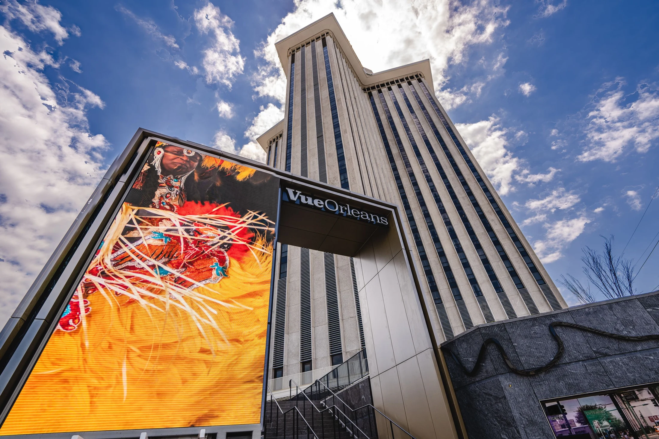 Vue Orleans entrance with colorful artwork beneath the tower and a blue sky